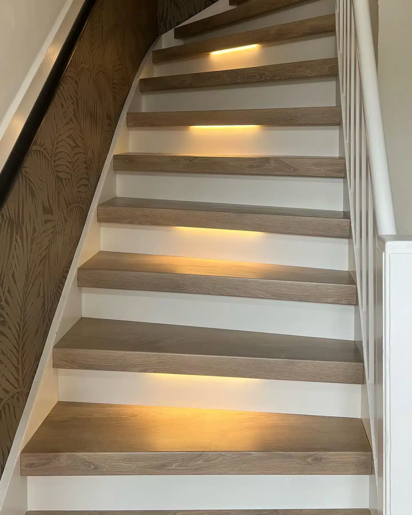 Dichte traprenovatie houten treden met witte stootborden met LED verlichting